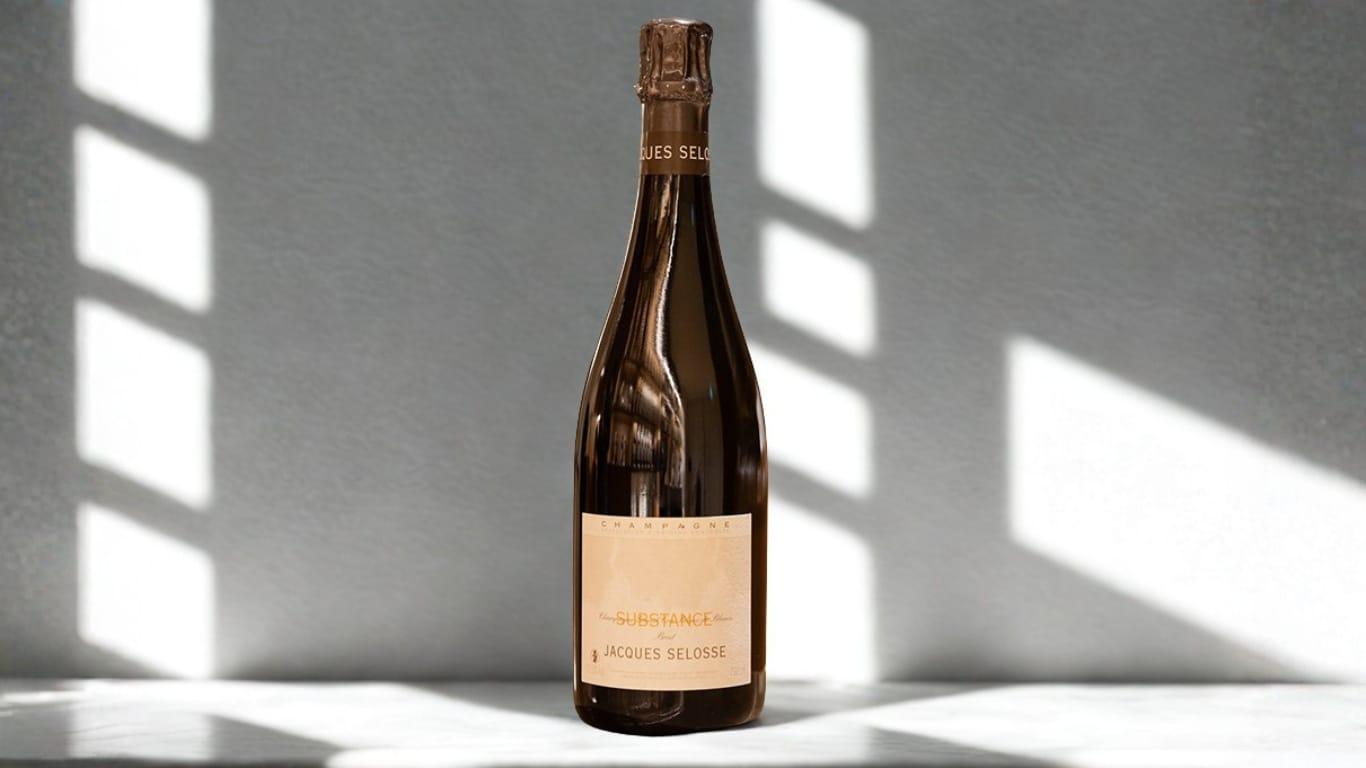 A bottle of Jacques Selosse Substance Champagne in soft window light against a marble surface — the cuvée whose solera began in 1986 and that built the grower-champagne movement.