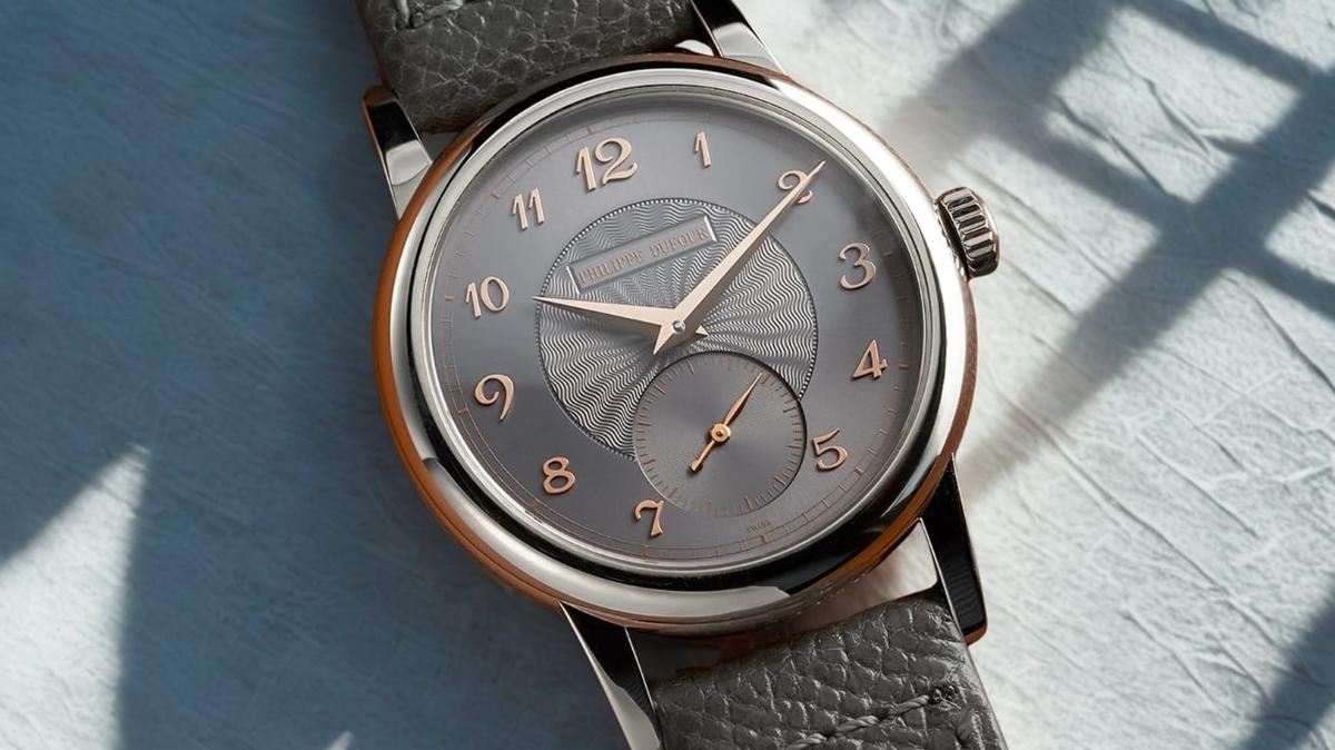 A Philippe Dufour Simplicity in white gold on a grey strap, its grey guilloche dial with rose gold Breguet numerals and a small seconds subdial.