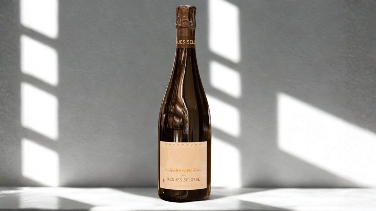 A bottle of Jacques Selosse Substance Champagne in soft window light against a marble surface — the cuvée whose solera began in 1986 and that built the grower-champagne movement.