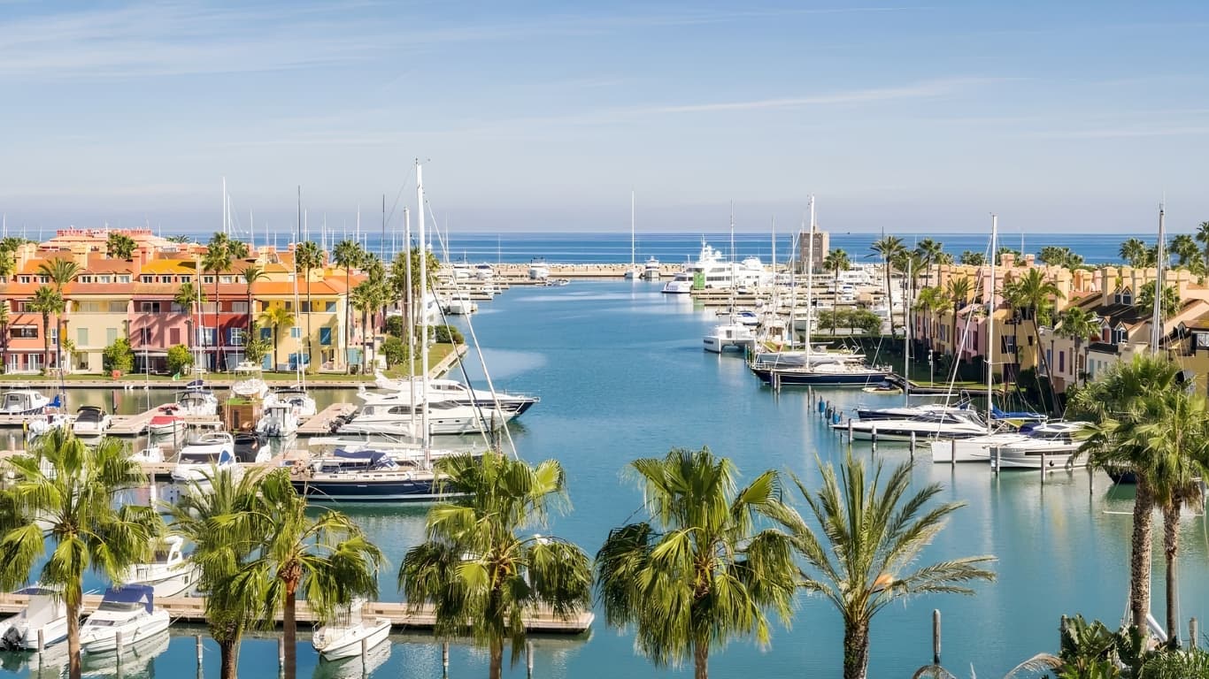 The Sotogrande marina in soft Andalusian light, palm-lined canals leading out to the Mediterranean — the 1962-planned community that quietly holds the highest-spend Spanish trophy addresses outside the islands.