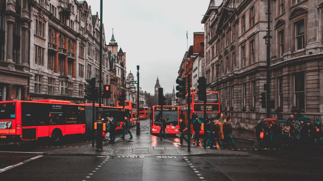 London re busses with pedestrians walking across the road