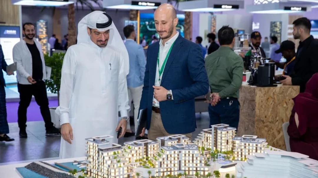 Investor on Acres Real Estate Exhibition looking at 
house model