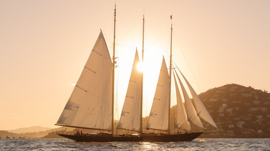 ATLANTIC silhouetted against a Côte d'Azur sunset, the kind of cruising scene that defines the modern Mediterranean charter market driving sector growth toward its 2032 valuation.