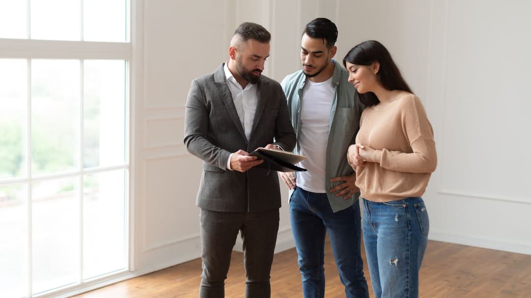 A couple with a real estate agent inside a property