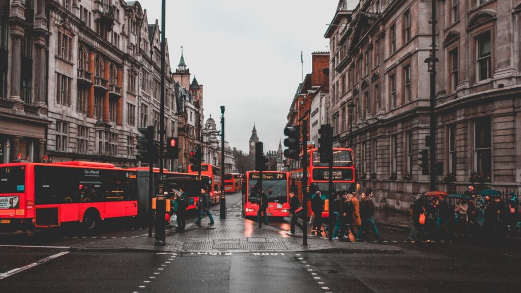 London re busses with pedestrians walking across the road